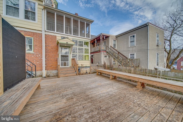 wooden deck featuring entry steps and a sunroom