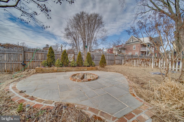 view of patio with an outdoor fire pit and a fenced backyard