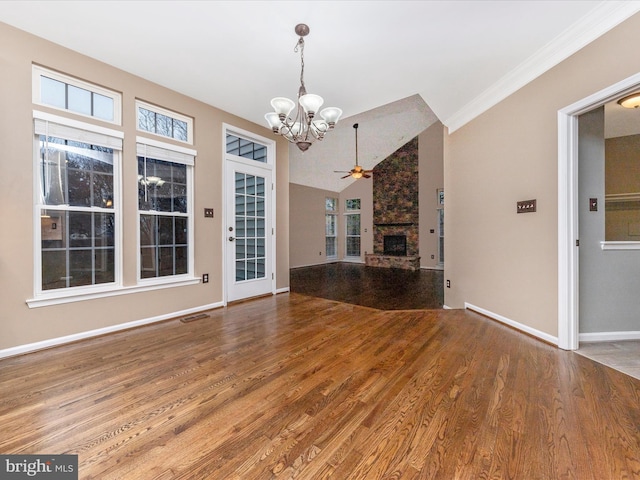 unfurnished living room featuring vaulted ceiling, a stone fireplace, ceiling fan with notable chandelier, wood-type flooring, and plenty of natural light