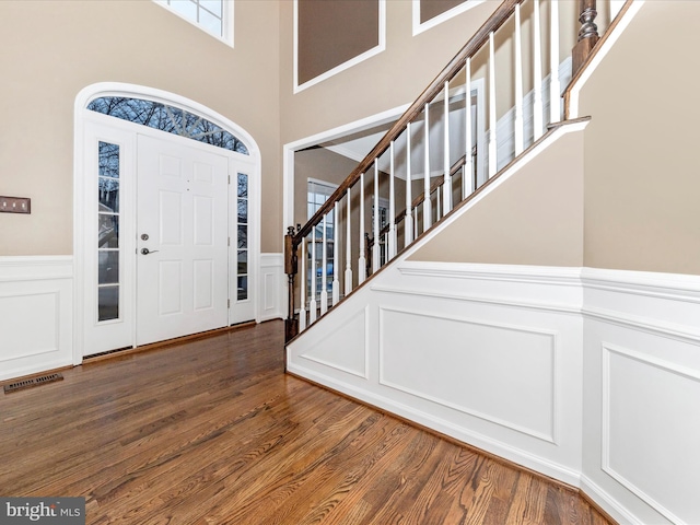 foyer with dark wood-type flooring and a towering ceiling