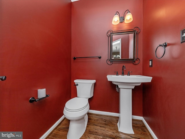 bathroom with wood-type flooring, sink, and toilet