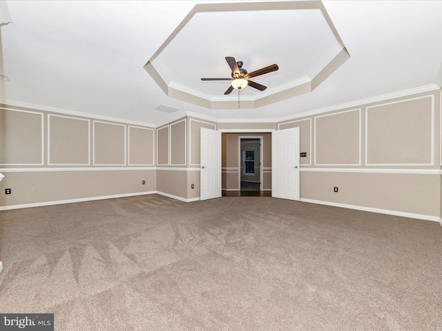 interior space with crown molding, carpet flooring, a tray ceiling, and ceiling fan