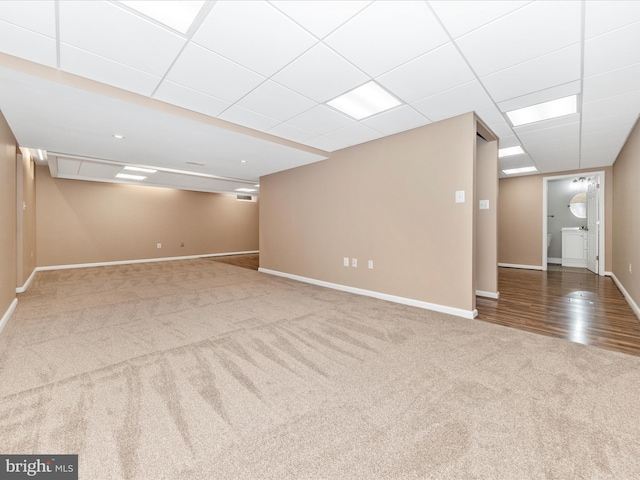 basement with a drop ceiling and carpet floors