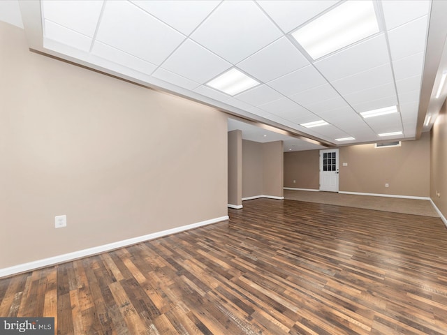 basement with a paneled ceiling and dark hardwood / wood-style floors