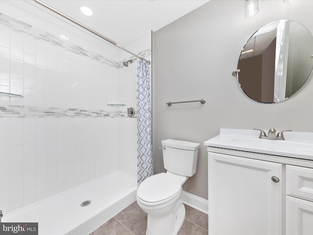 bathroom with a shower with curtain, vanity, tile patterned floors, and toilet