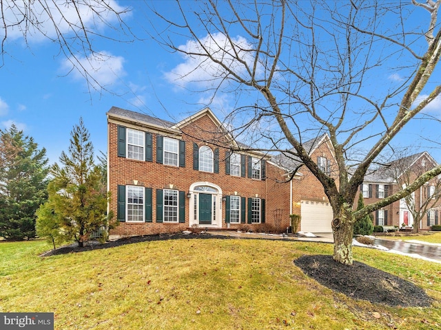 colonial-style house featuring a garage and a front yard