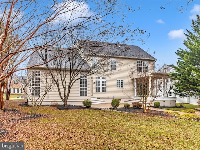 back of house with a lawn and a patio