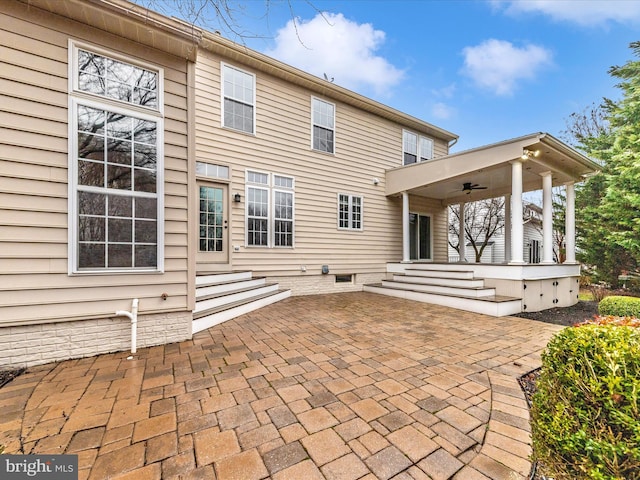 rear view of property featuring ceiling fan and a patio area