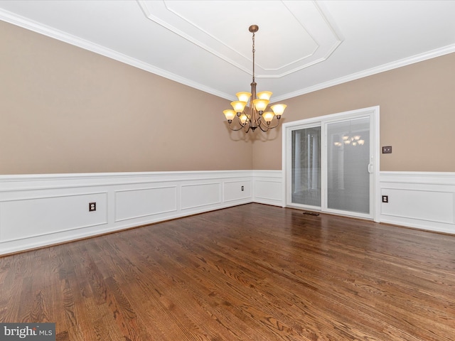 unfurnished dining area with dark wood-type flooring, ornamental molding, and a chandelier