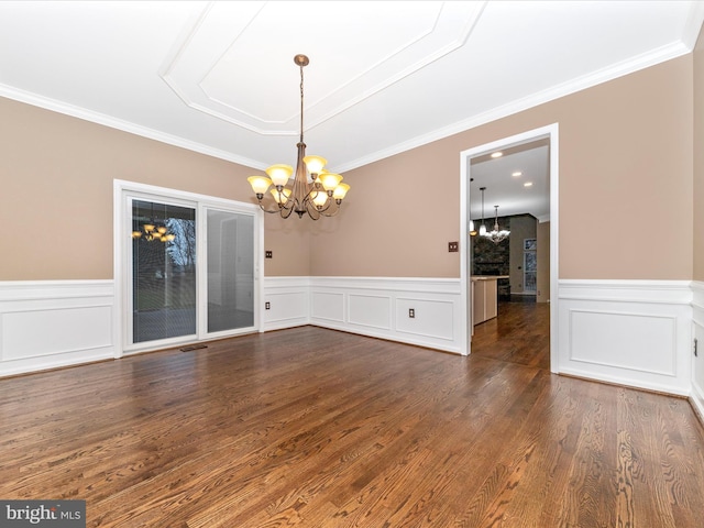 unfurnished dining area with ornamental molding, dark wood-type flooring, and a chandelier