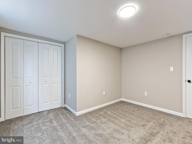 unfurnished bedroom featuring carpet flooring and a closet