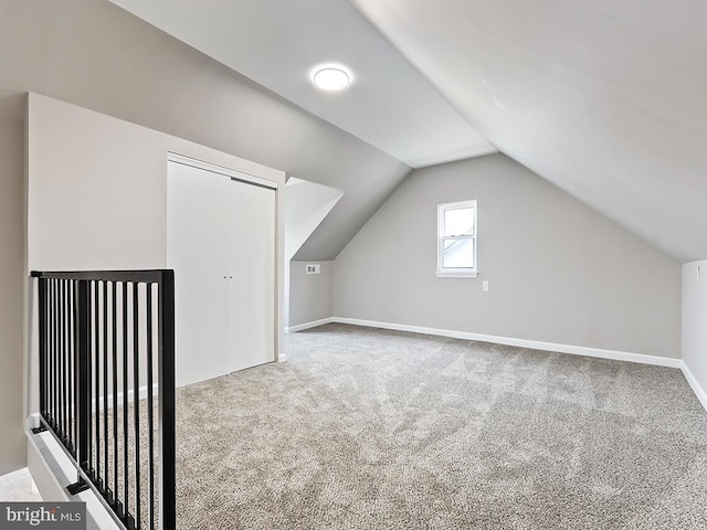 additional living space with lofted ceiling and carpet flooring