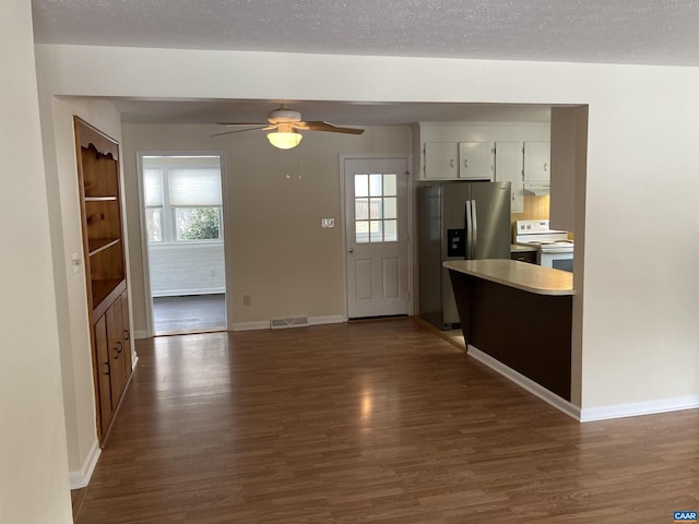 kitchen featuring stainless steel refrigerator with ice dispenser, dark wood-type flooring, a textured ceiling, and white range with electric stovetop