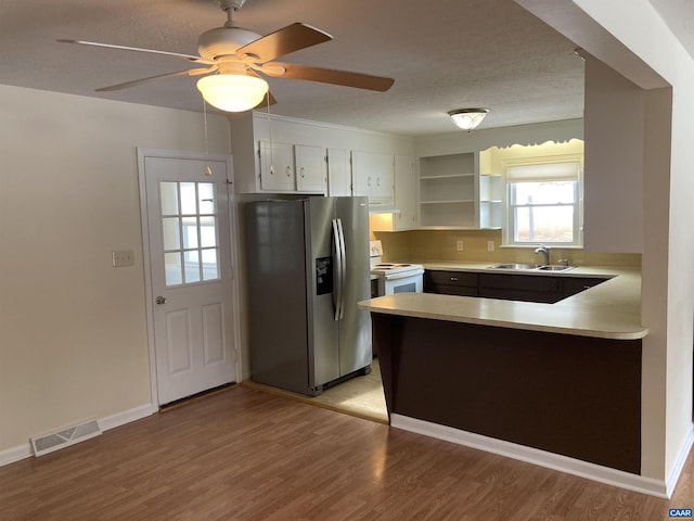 kitchen with sink, light hardwood / wood-style flooring, white electric stove, stainless steel fridge, and white cabinets