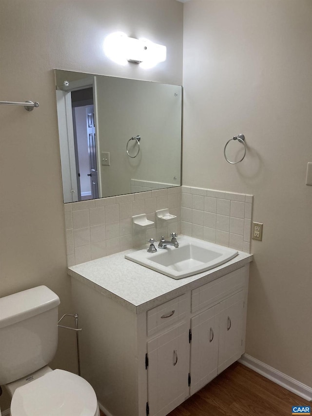 bathroom featuring tasteful backsplash, vanity, toilet, and hardwood / wood-style flooring