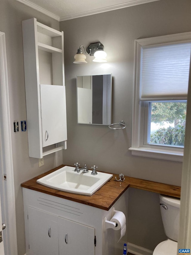 bathroom with crown molding, vanity, and toilet