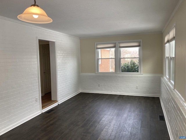 unfurnished room featuring ornamental molding, brick wall, and dark hardwood / wood-style floors