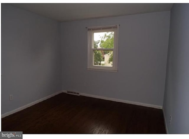 spare room with dark wood-type flooring