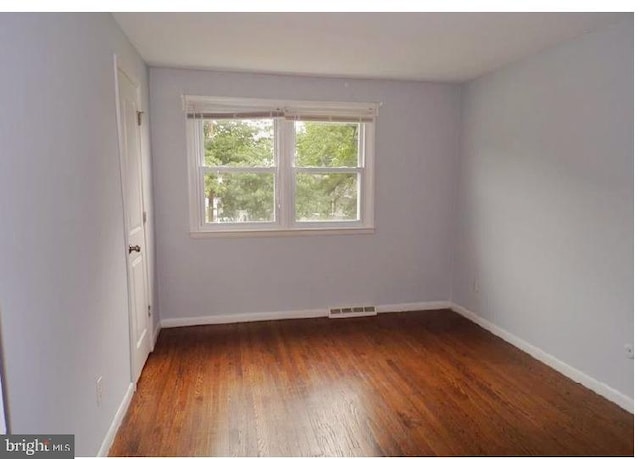 empty room featuring dark hardwood / wood-style flooring