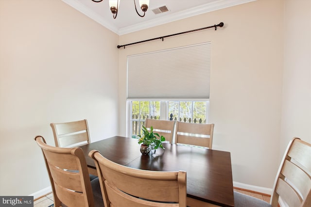 dining space with ornamental molding and an inviting chandelier