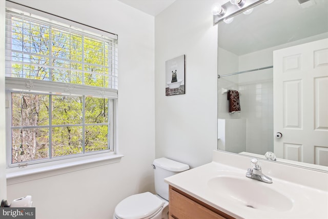 bathroom with vanity, toilet, and a shower