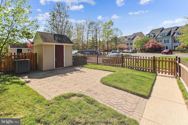 view of yard with cooling unit, a storage shed, and a patio area