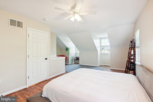 bedroom with hardwood / wood-style flooring, vaulted ceiling, and ceiling fan