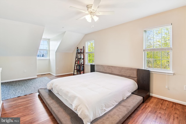 bedroom with multiple windows, wood-type flooring, vaulted ceiling, and ceiling fan