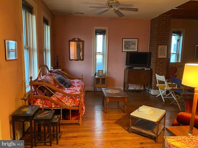 living room featuring wood-type flooring and ceiling fan