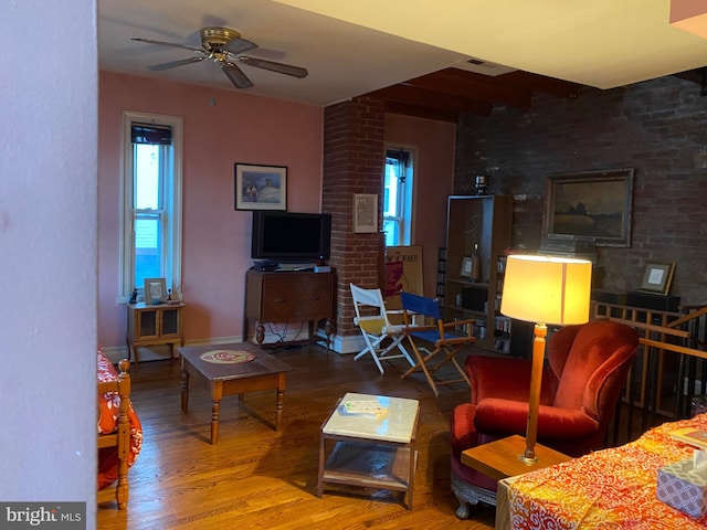 living room featuring hardwood / wood-style floors, beam ceiling, and ceiling fan