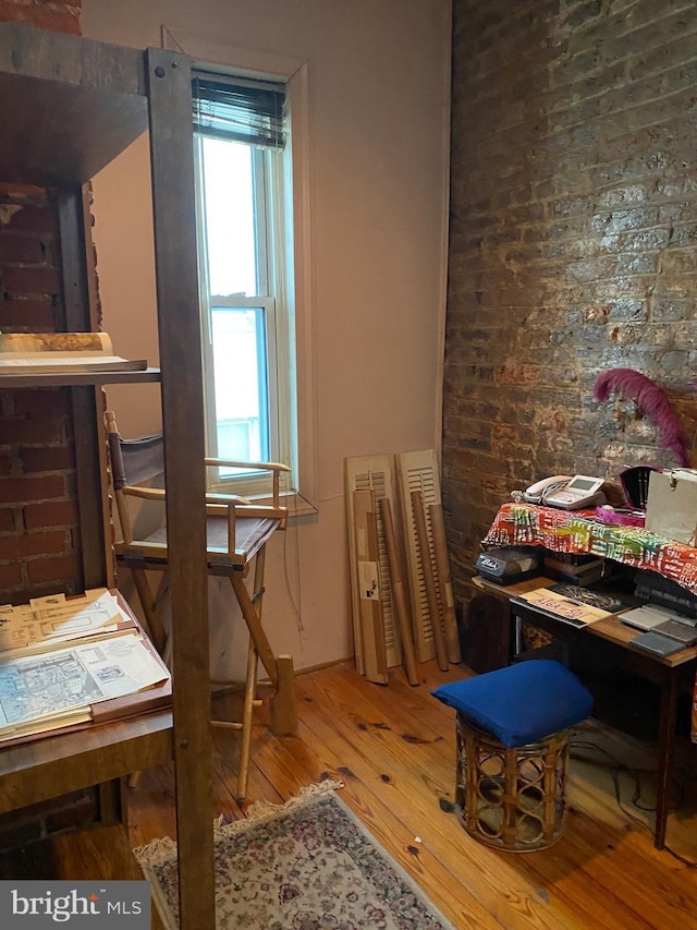 interior space featuring hardwood / wood-style floors and brick wall