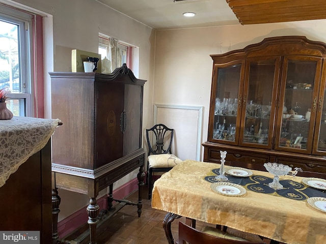 dining space with dark parquet flooring