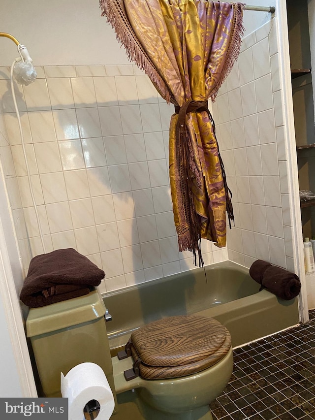 bathroom with toilet, a bathing tub, and tile patterned flooring