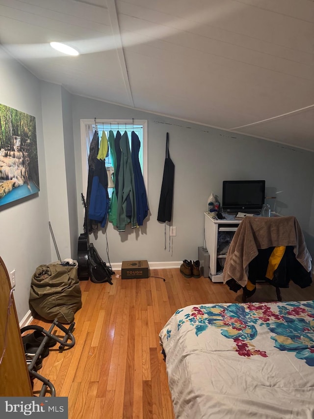 bedroom with hardwood / wood-style floors and vaulted ceiling