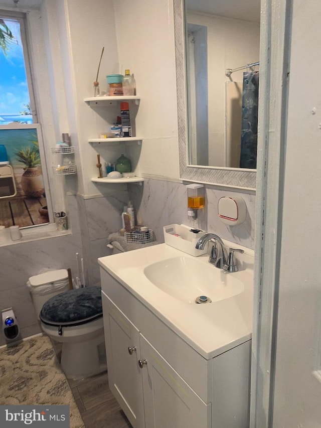 bathroom with tile walls, vanity, decorative backsplash, toilet, and walk in shower