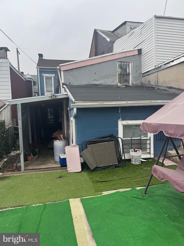 back of house featuring a lawn