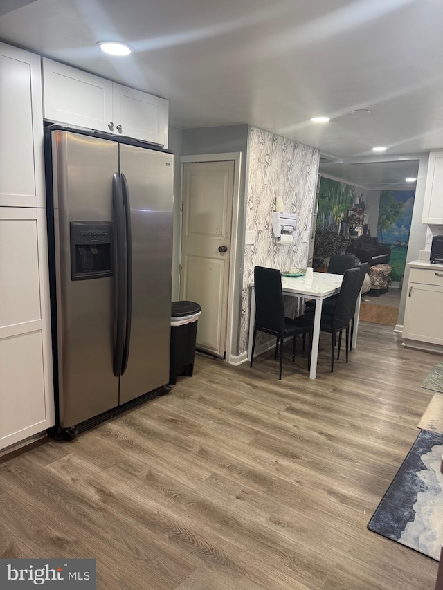 kitchen featuring white cabinetry, light hardwood / wood-style floors, and stainless steel refrigerator with ice dispenser