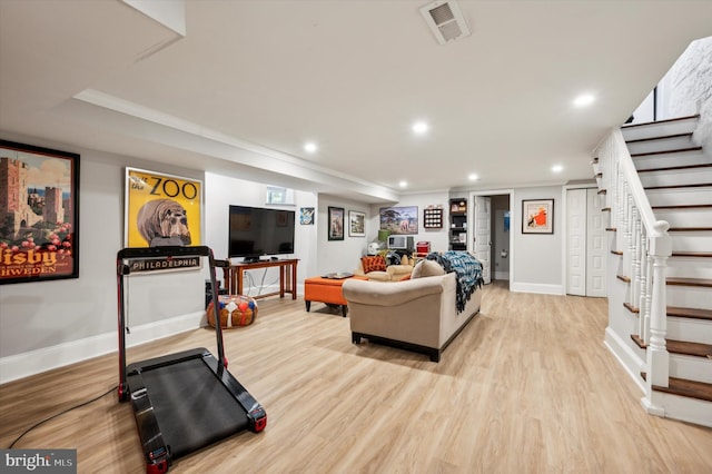 exercise area featuring crown molding and light hardwood / wood-style flooring