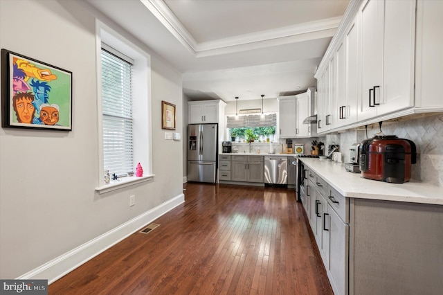 kitchen with backsplash, decorative light fixtures, dark wood-type flooring, and appliances with stainless steel finishes