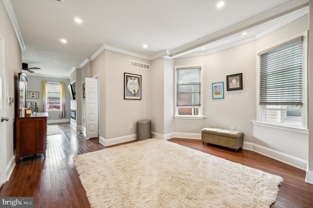 living area with crown molding, ceiling fan, and dark hardwood / wood-style flooring