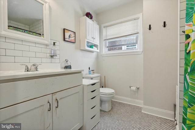 bathroom featuring vanity, decorative backsplash, a shower with curtain, and toilet