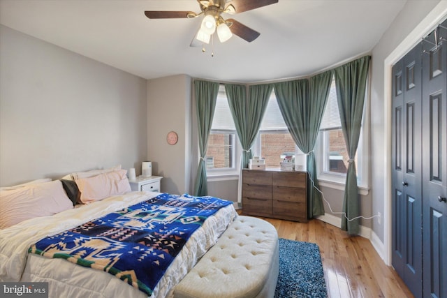 bedroom with multiple windows, light hardwood / wood-style flooring, and a closet