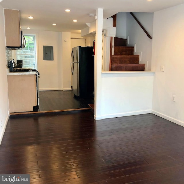 kitchen with dark hardwood / wood-style flooring, electric panel, and refrigerator