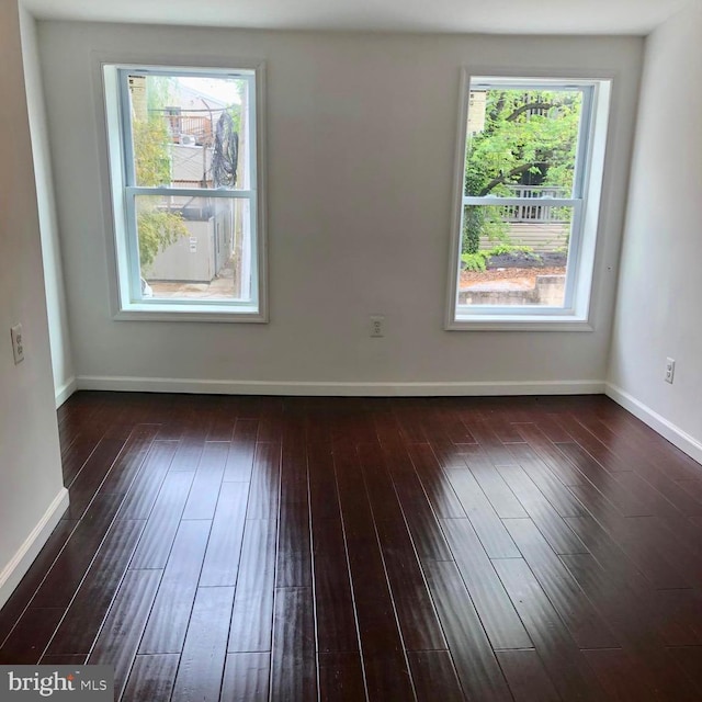 unfurnished room with dark wood-type flooring