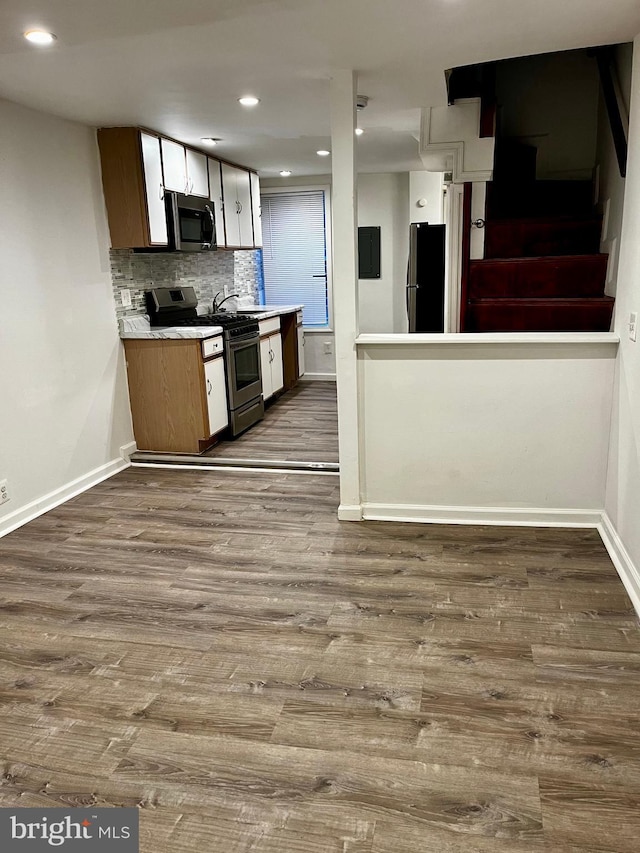 kitchen with tasteful backsplash, wood-type flooring, appliances with stainless steel finishes, and sink