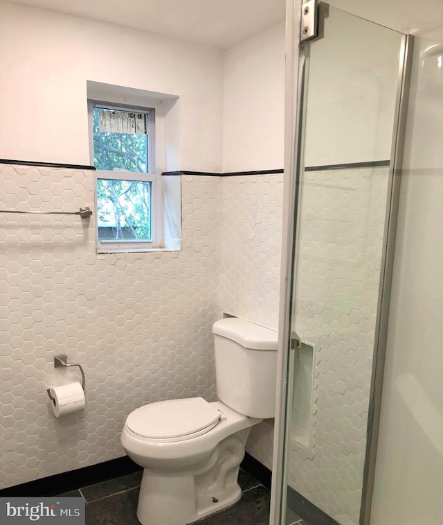 bathroom with tile walls, tile patterned floors, and toilet