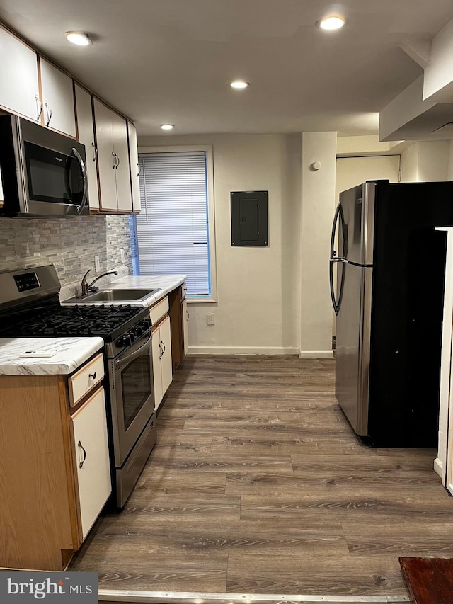 kitchen with dark wood-type flooring, sink, white cabinetry, appliances with stainless steel finishes, and electric panel