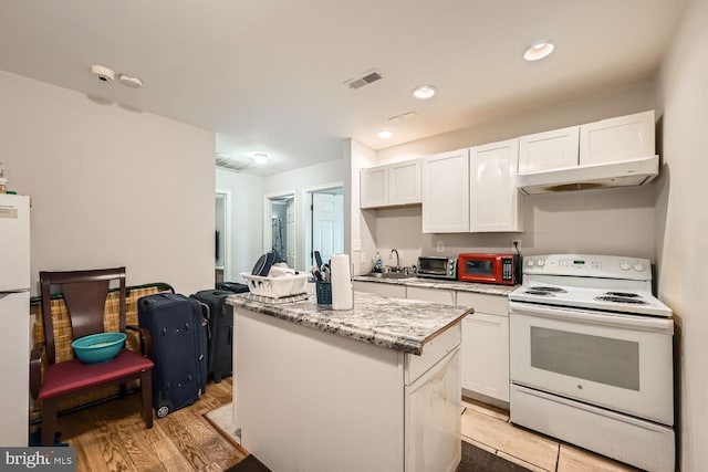 kitchen featuring white cabinetry, sink, a center island, light hardwood / wood-style floors, and white appliances