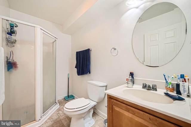 bathroom with vanity, a shower with door, and toilet