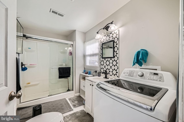 bathroom with walk in shower, vanity, washer / clothes dryer, and toilet